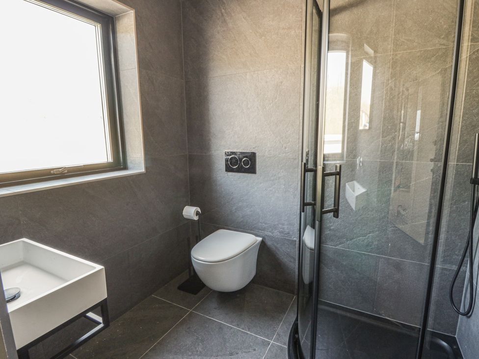 A bathroom featuring a shower, toilet, and hand basin at Brynseion Uchaf near Aberystwyth