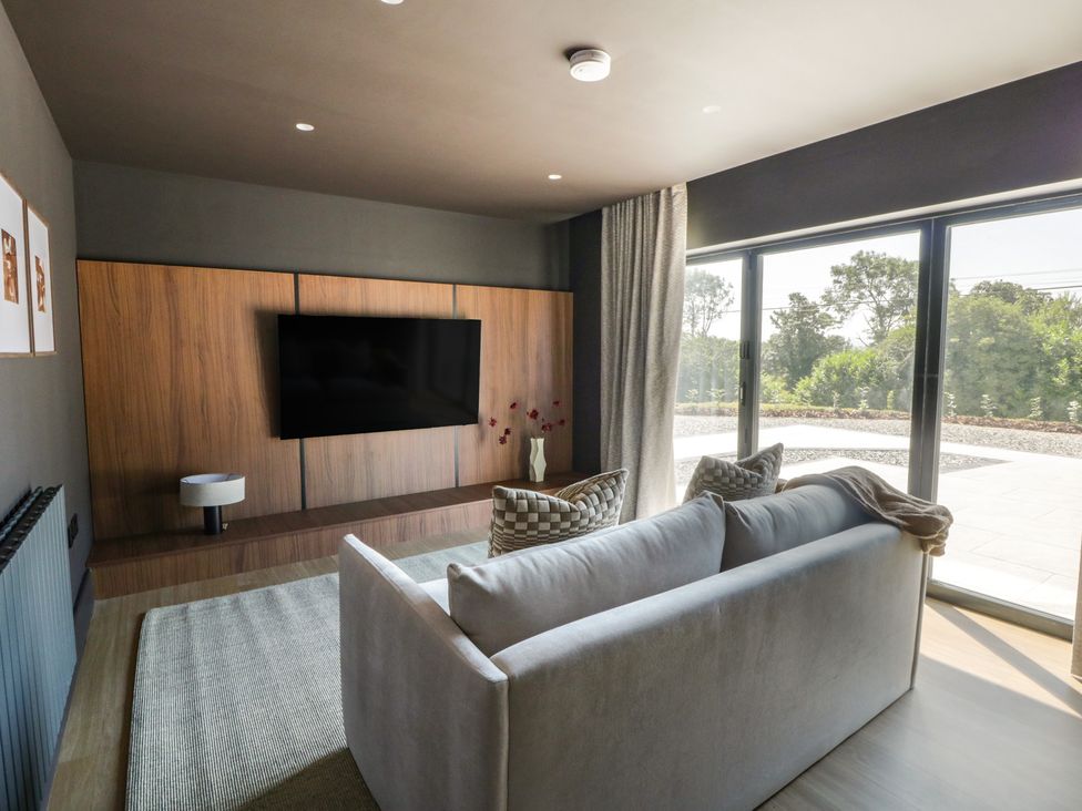 A living room with a television and sofa at Brynseion Uchaf near Aberystwyth