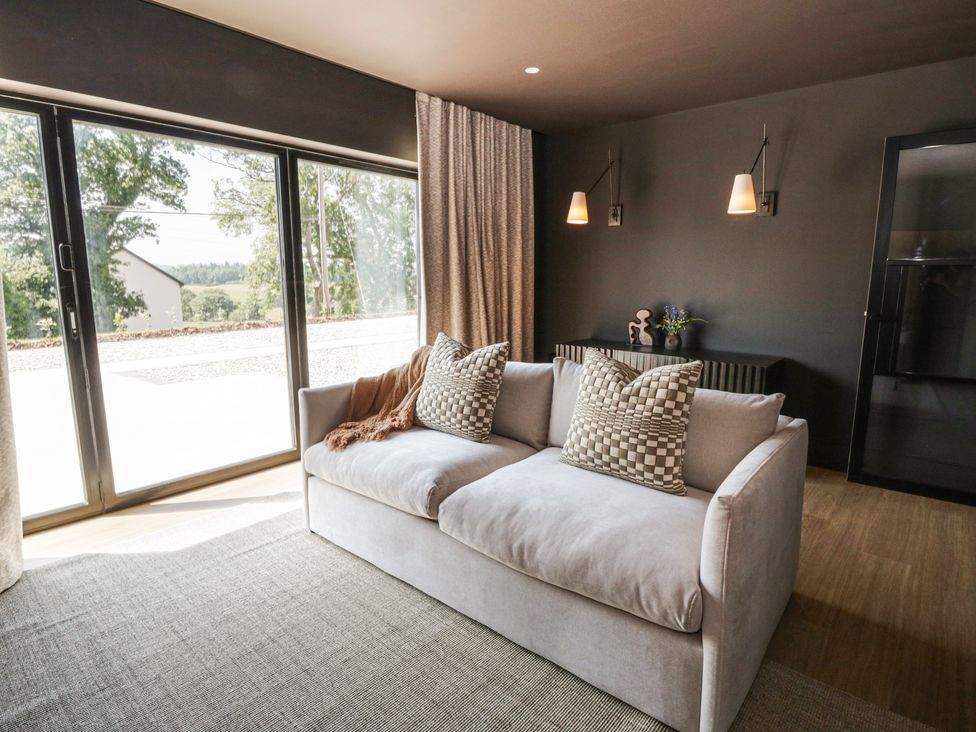 A living room with a sofa and large windows at Brynseion Uchaf near Aberystwyth