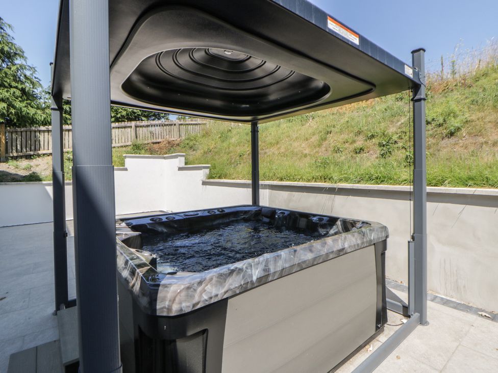 A hot tub with a canopy in a garden at Brynseion Uchaf near Aberystwyth