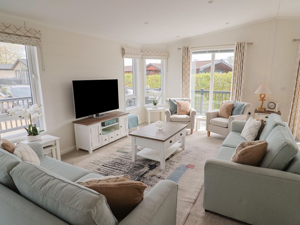 A living room with a television and seating at Hazelwood 3 in Pinewood Retreat in Rousdon near Lyme Regis