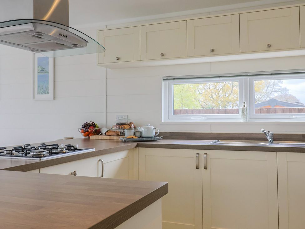A kitchen with a gas stove and fruit bowl at Hazelwood 3 Pinewood Retreat in Rousdon near Lyme Regis