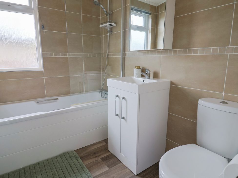 A bathroom with a bathtub, sink, and toilet at Hazelwood 3 Pinewood Retreat in Rousdon near Lyme Regis
