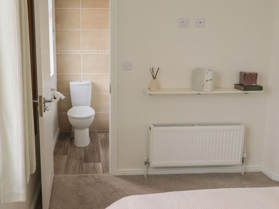 A bathroom with a toilet and shelf at Hazelwood 3, Pinewood Retreat in Rousdon near Lyme Regis