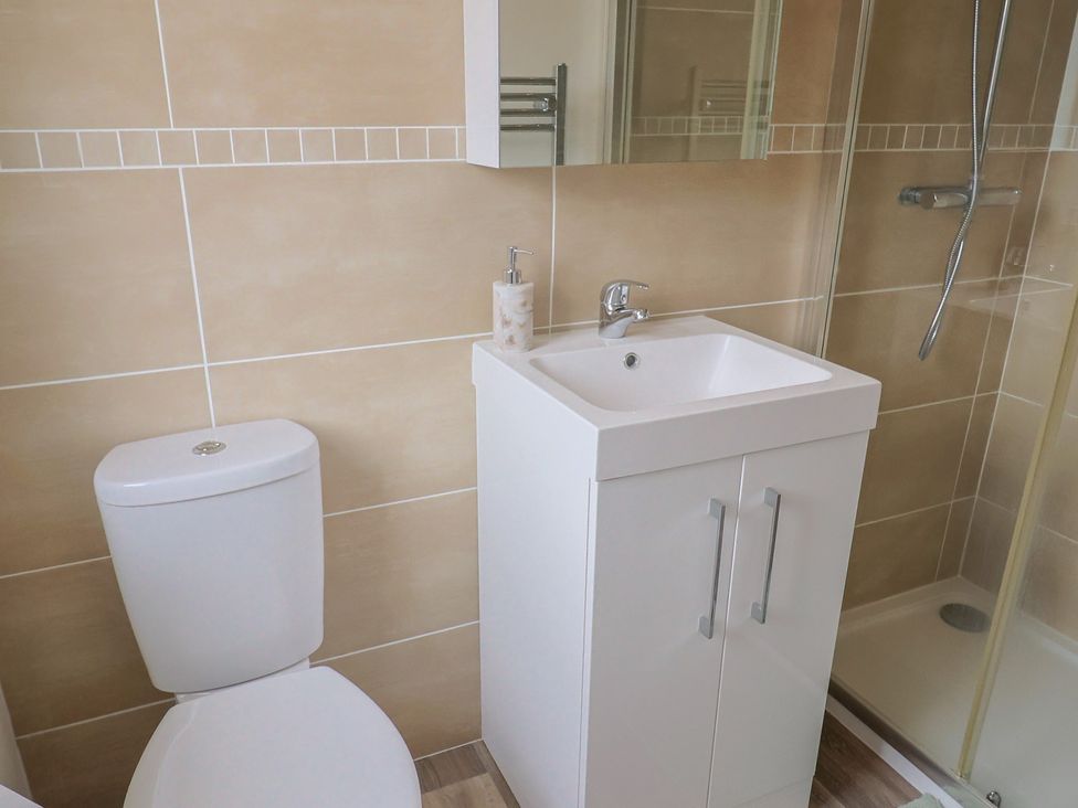 A bathroom with a shower, sink, toilet and towel rack at Hazelwood 3, Pinewood Retreat in Rousdon near Lyme Regis