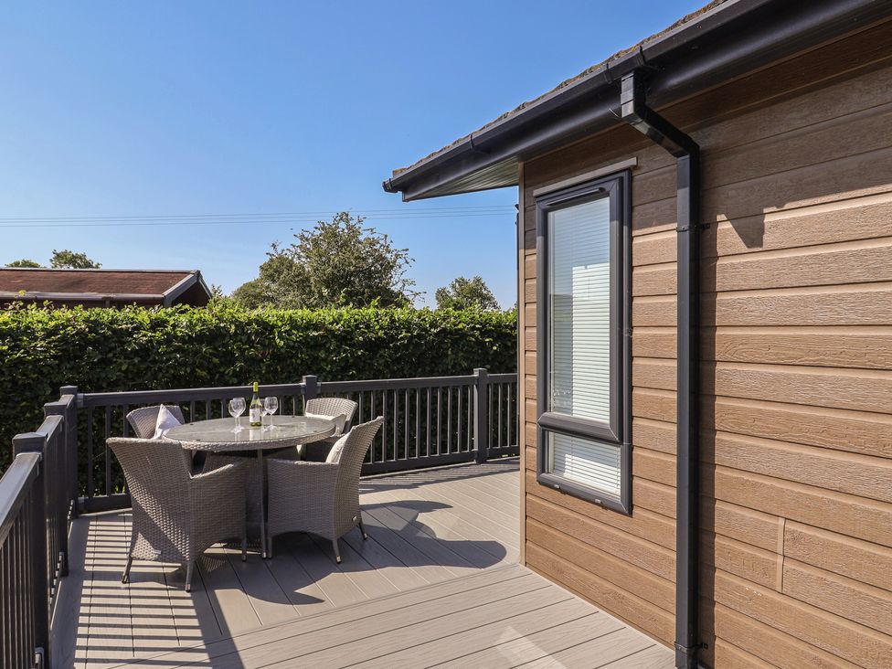 A deck area with a table and chairs at Hazelwood 3 Pinewood Retreat in Rousdon near Lyme Regis