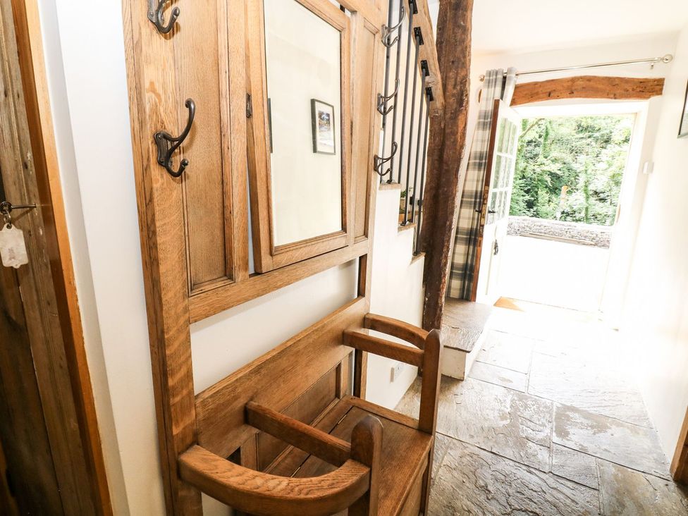 A hallway with a bench and hooks at The Barn