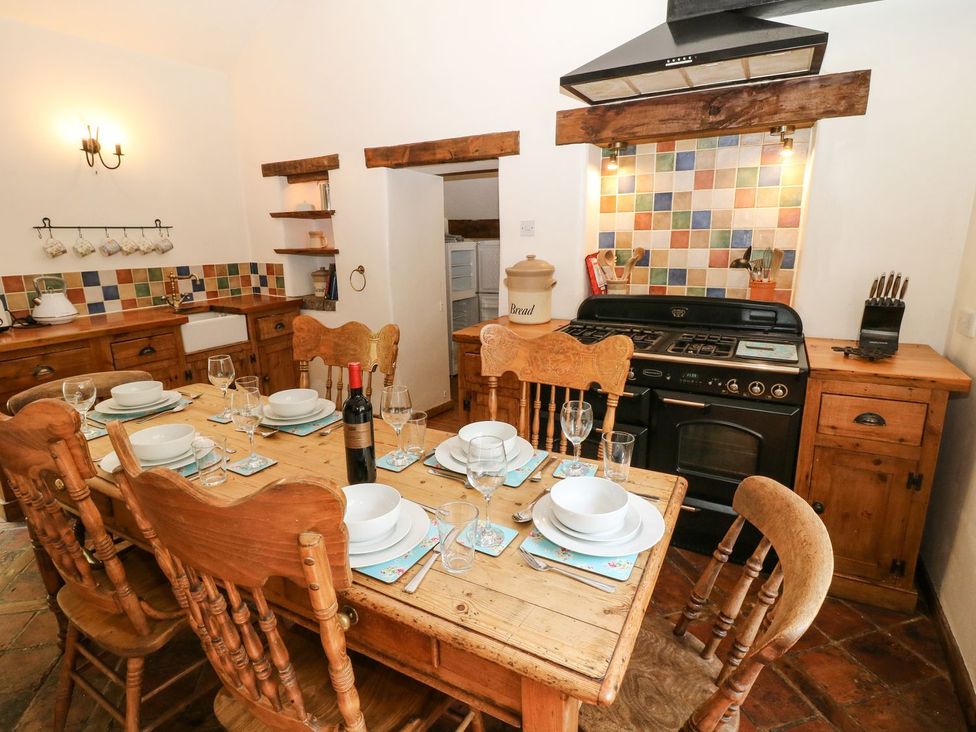 A kitchen with a dining table set for dinner at The Barn