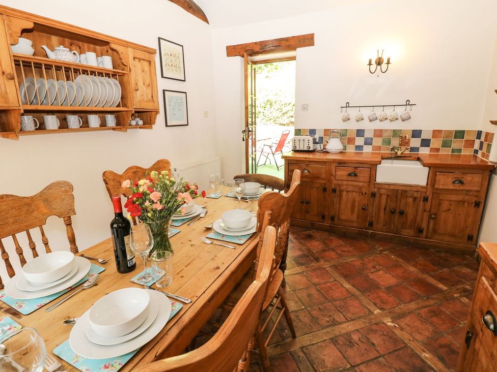 A dining room with a wooden table and chairs at The Barn in 