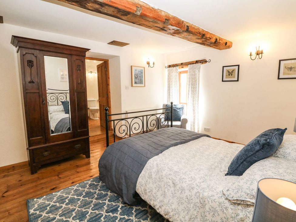 A bedroom with a bed and wardrobe at The Barn in 
