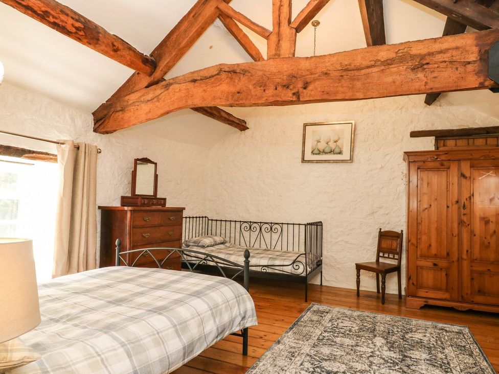 A bedroom with a bed and wardrobe at The Barn in 