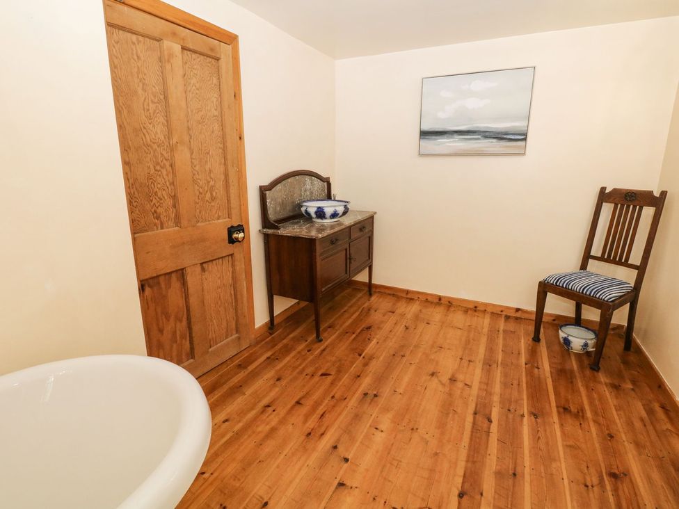 A bathroom with a bathtub and a vanity at The Barn in 