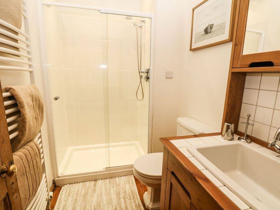 A bathroom with a shower, toilet, and sink at The Barn