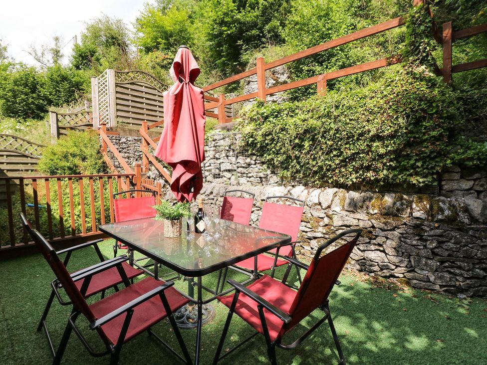 A garden with a table and chairs under an umbrella at The Barn