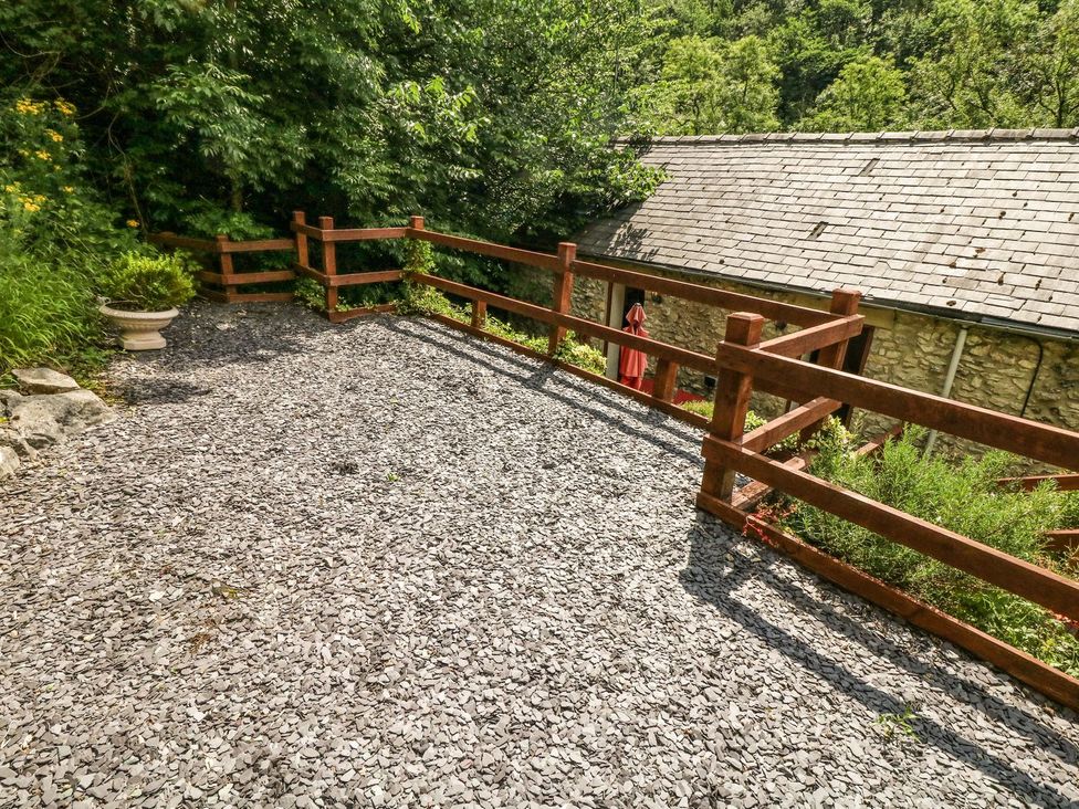 An outdoor area with a gravel surface and wooden fence at The Barn