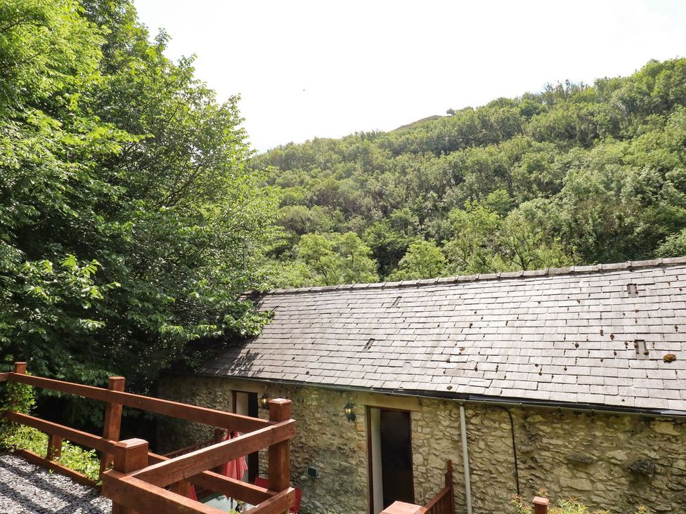 An outdoor view of a stone building with trees and hills at The Barn in 