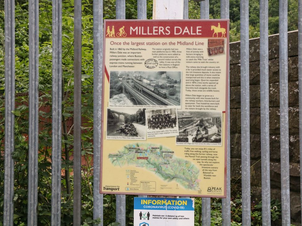 An information board about Millers Dale station near a railway at The Barn 