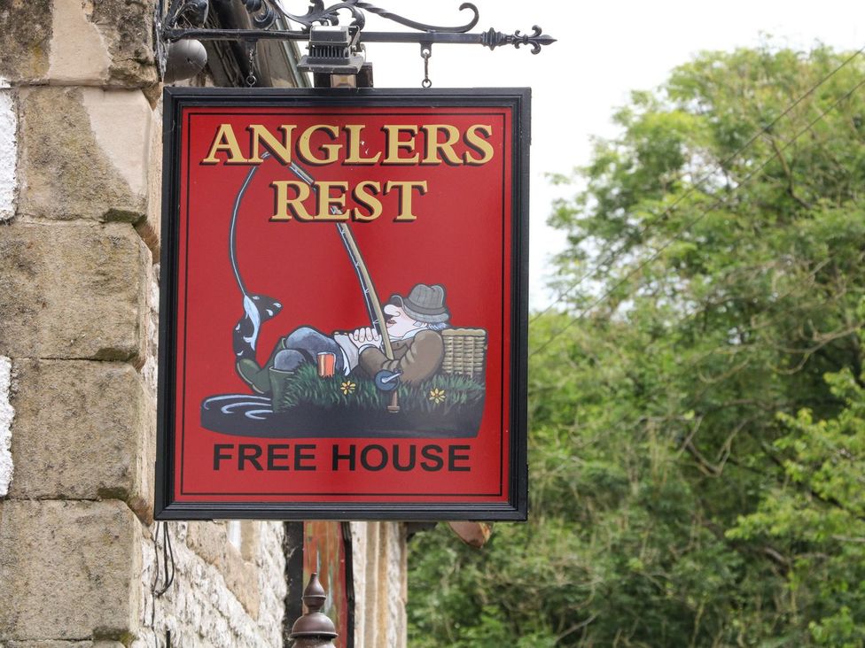 A sign for Anglers Rest with a fishing theme