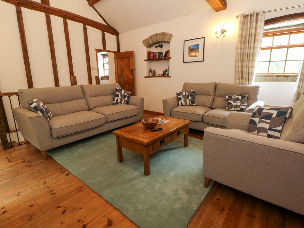 A living room with sofas and a coffee table at The Barn in Miller's Dale near Tideswell