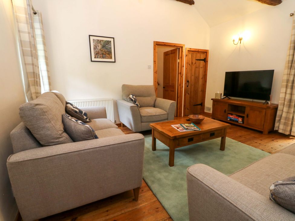 A living room with sofas and a television at The Barn in Miller's Dale near Tideswell