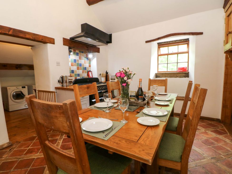 A kitchen with a dining table set at The Barn in Miller's Dale near Tideswell