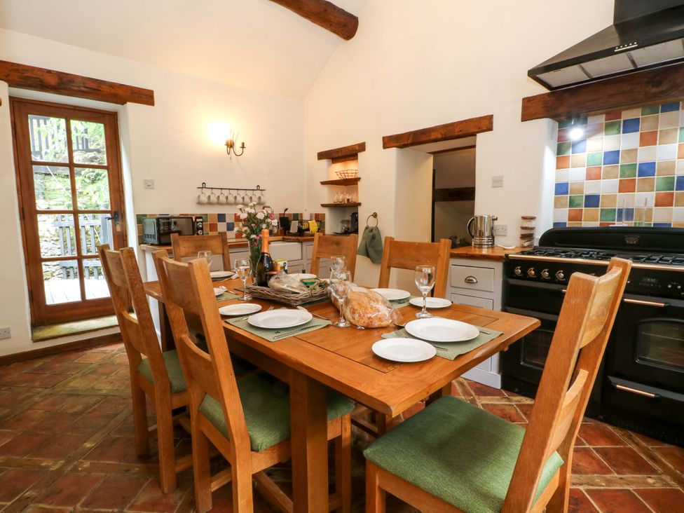 A kitchen with a table and chairs at The Barn in Miller's Dale near Tideswell