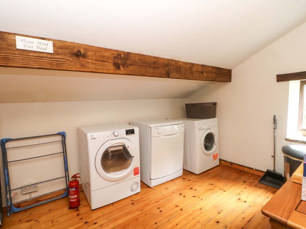 A laundry room with appliances and a window at The Barn in Miller's Dale near Tideswell