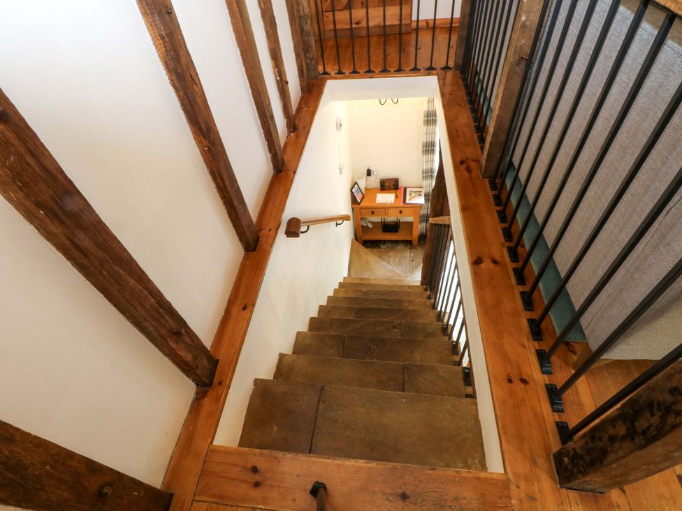 A staircase with wooden beams and desk at The Barn in Miller's Dale near Tideswell