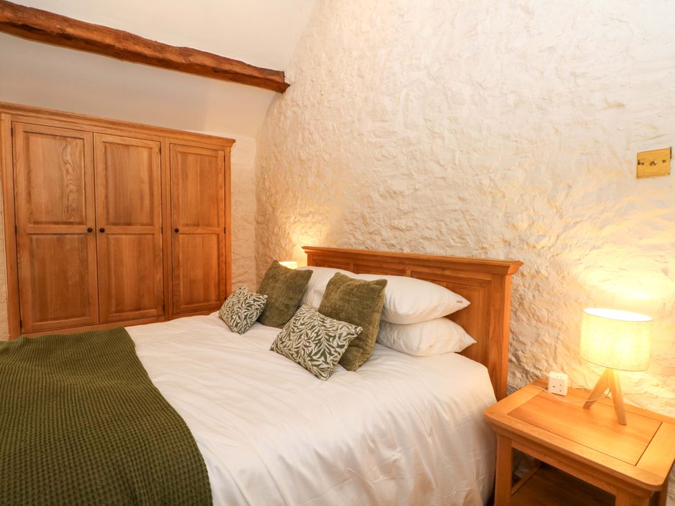 A bedroom with a bed and wardrobe at The Barn in Miller's Dale near Tideswell