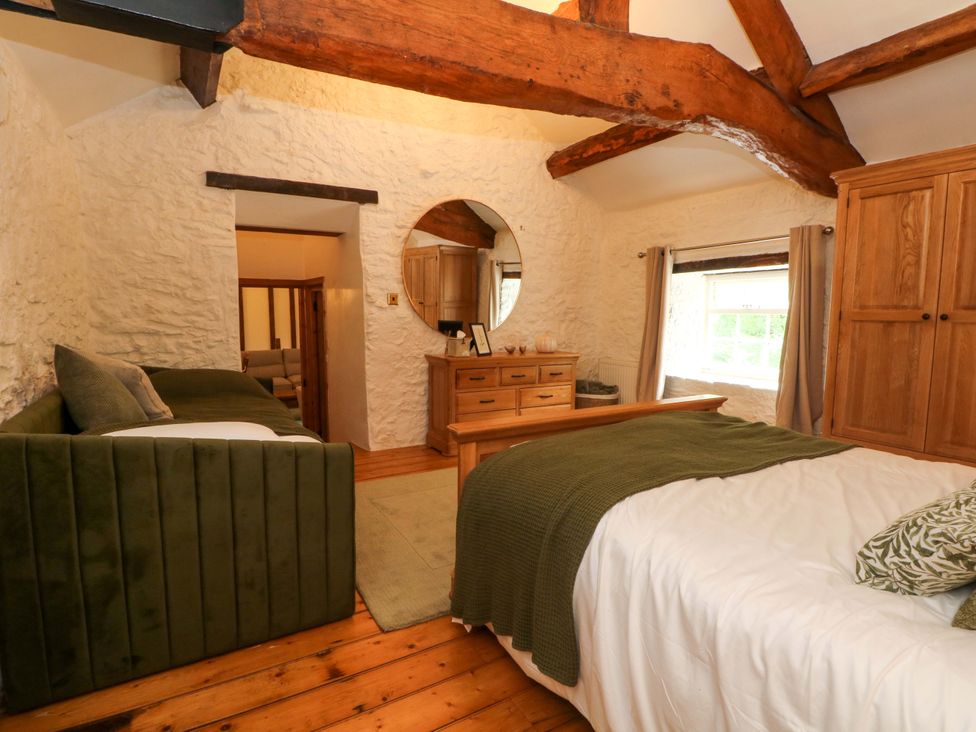 A bedroom with a bed and a sofa at The Barn in Miller's Dale near Tideswell