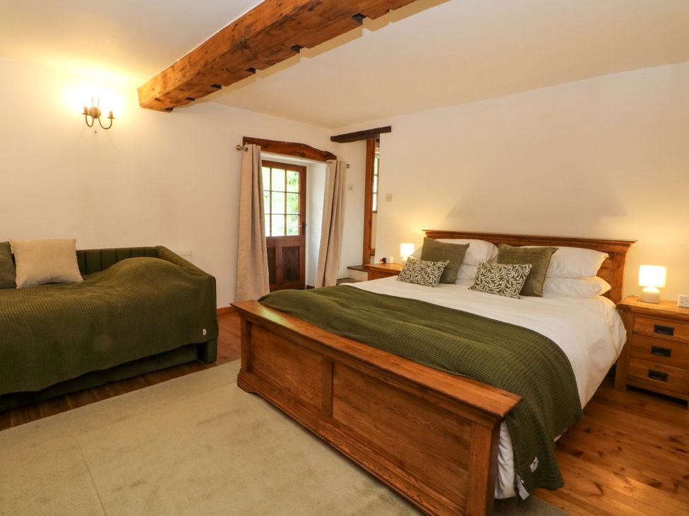 A bedroom with a bed and a sofa at The Barn in Miller's Dale near Tideswell