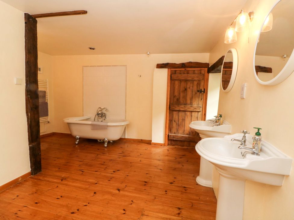 A bathroom with a bathtub and two sinks at The Barn in Miller's Dale near Tideswell