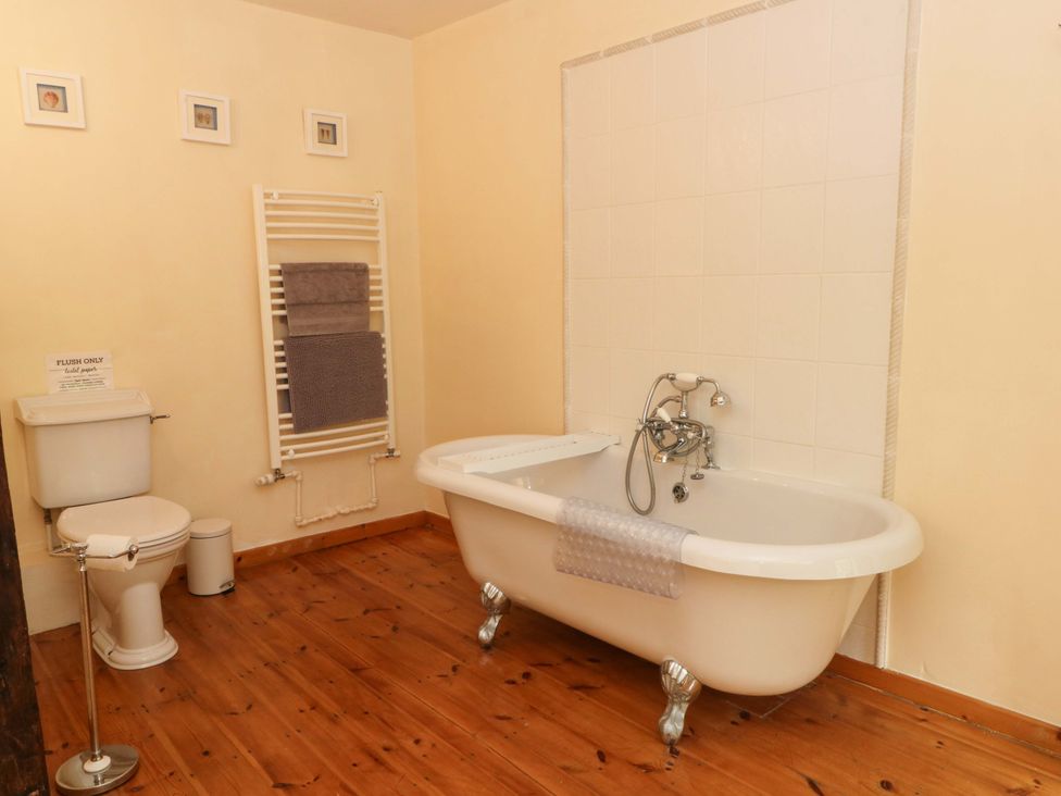 A bathroom with a bathtub and a toilet at The Barn in Miller's Dale near Tideswell