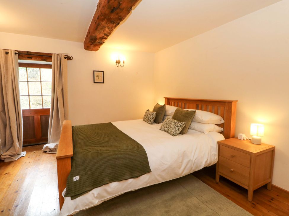 A bedroom with a bed and bedside table at The Barn in Miller's Dale near Tideswell