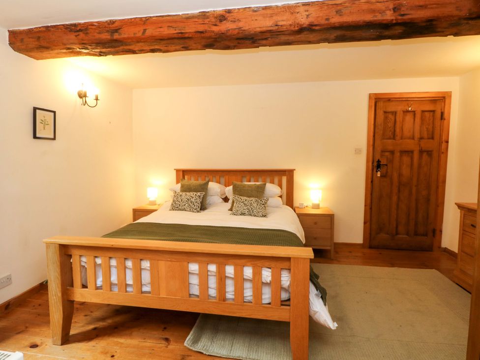 A bedroom with a wooden bed and side tables at The Barn in Miller's Dale near Tideswell