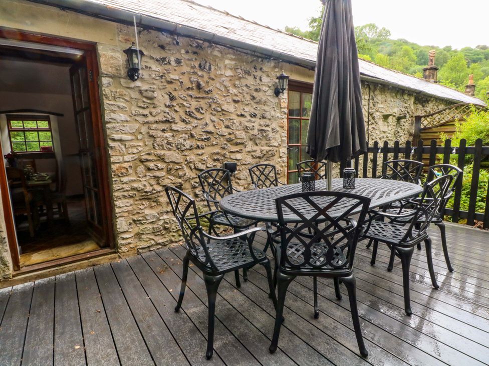 An outdoor seating area with a table and chairs at The Barn in Miller's Dale near Tideswell