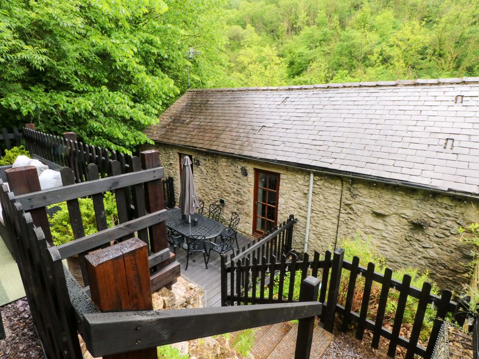An outdoor area with seating and a stone building at The Barn in Miller's Dale near Tideswell