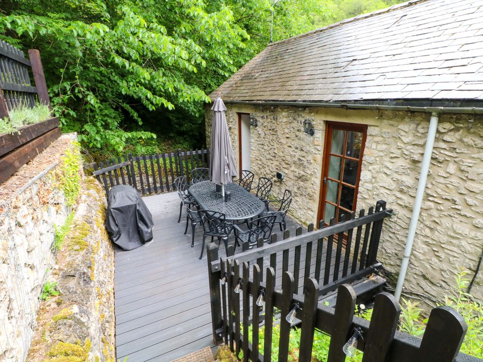 An outdoor deck with a table and chairs at The Barn in Miller's Dale near Tideswell