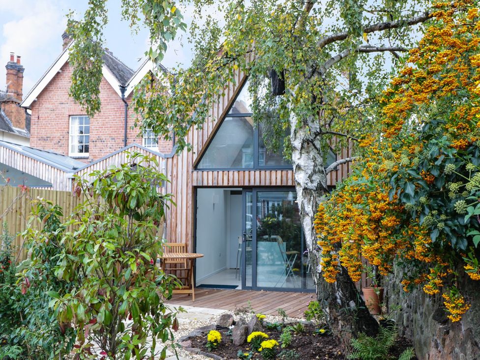 A garden with a wooden house and plants at Little Mornington in Malvern