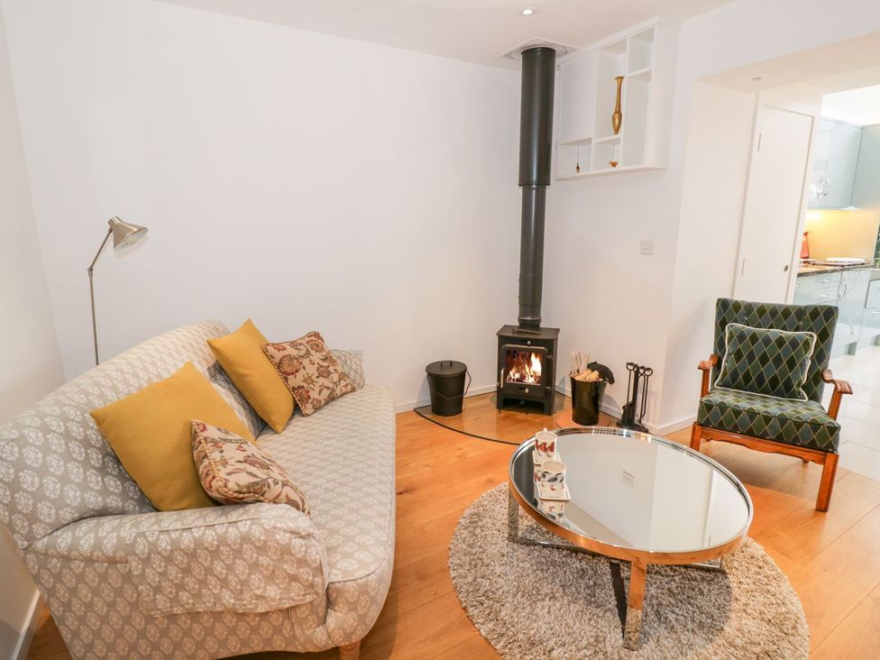 A living room with a sofa, coffee table, and fireplace at Little Mornington in Malvern