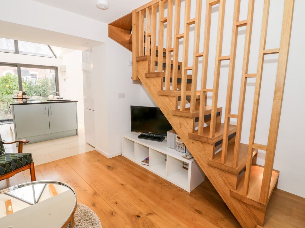A living room with a staircase and a television at Little Mornington in Malvern