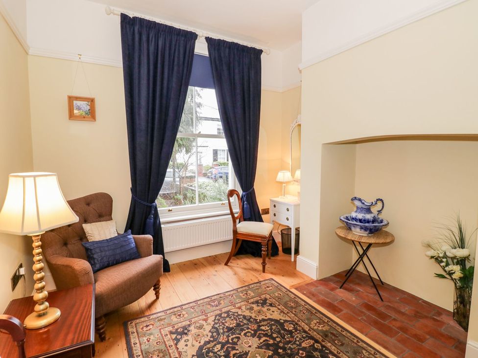 A living room with an armchair and a lamp at Little Mornington in Malvern