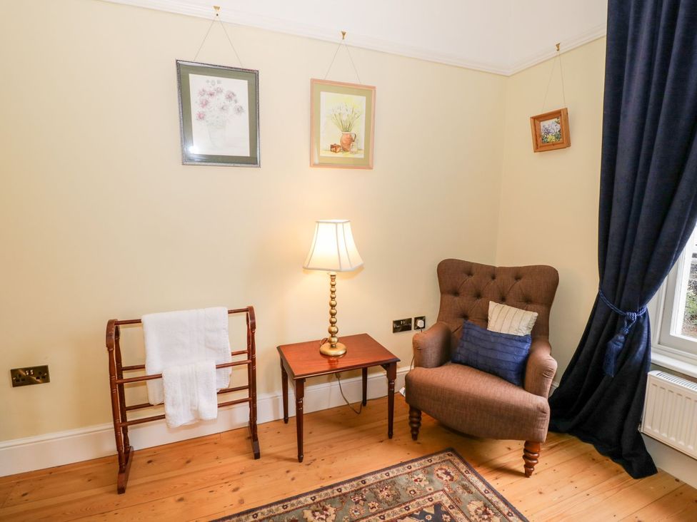 A living room with a chair and lamp at Little Mornington in Malvern