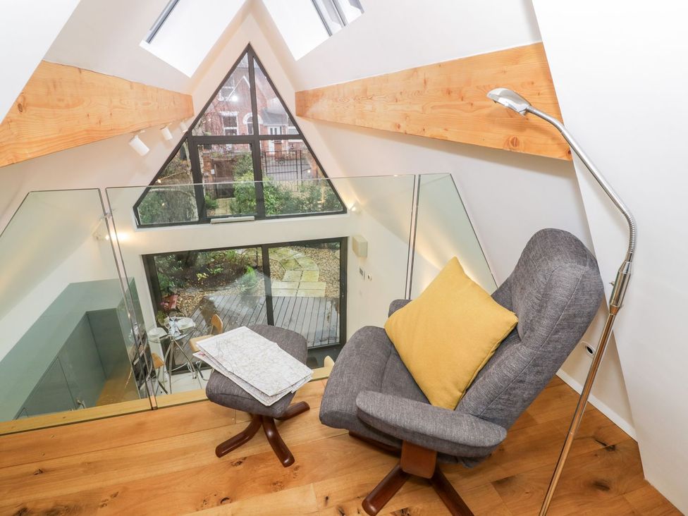A living room with a chair and table at Little Mornington in Malvern