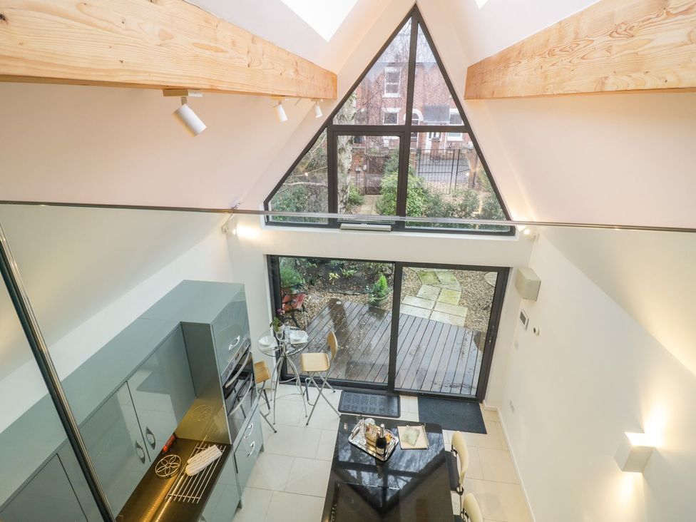 A kitchen with a dining table and sliding doors leading to an outdoor space at Little Mornington in Malvern