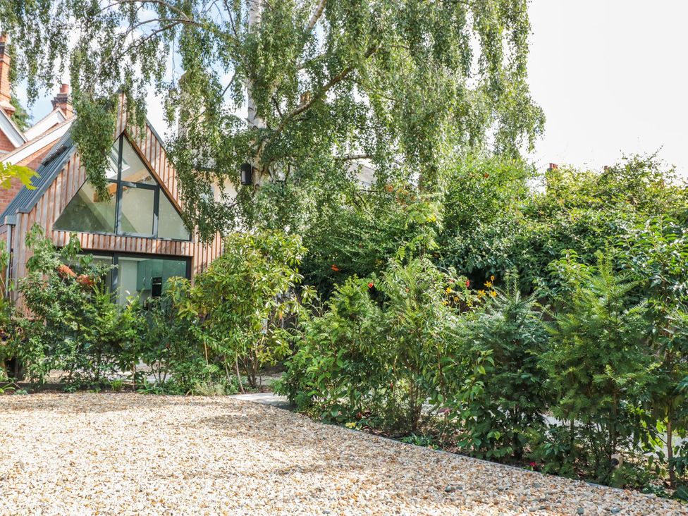 A garden with a house and greenery at Little Mornington in Malvern