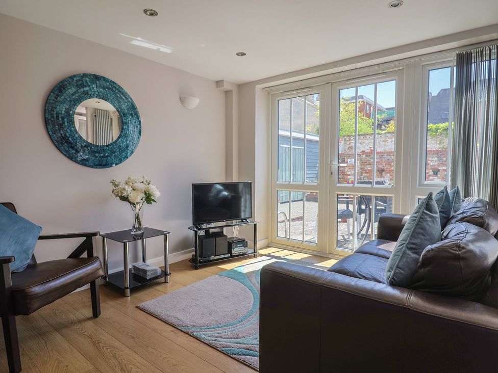 A living room with a sofa and television at Beck House in Weymouth