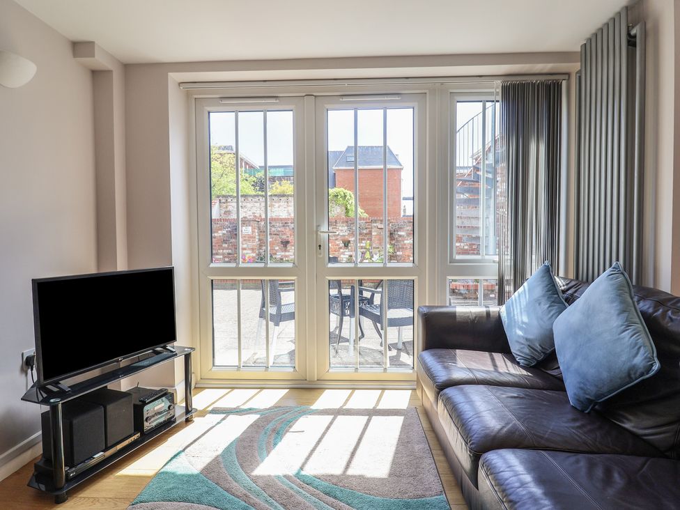 A living room with a TV and a sofa at Beck House in Weymouth