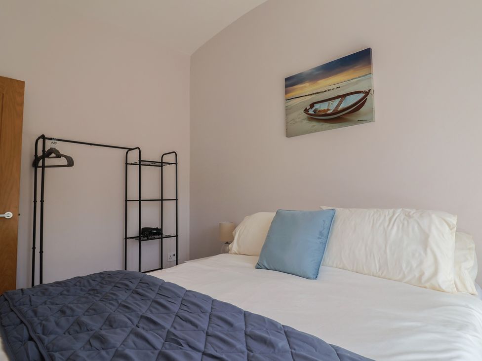 A bedroom with a bed and clothes rack at Beck House in Weymouth