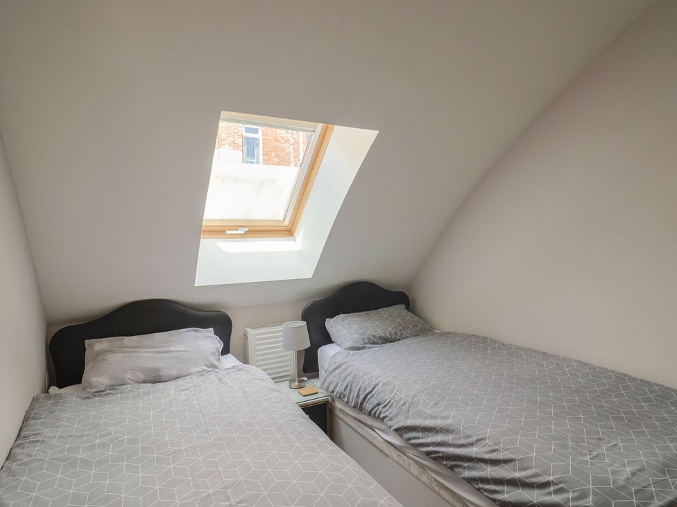 A bedroom with two beds and a window at Beck House in Weymouth